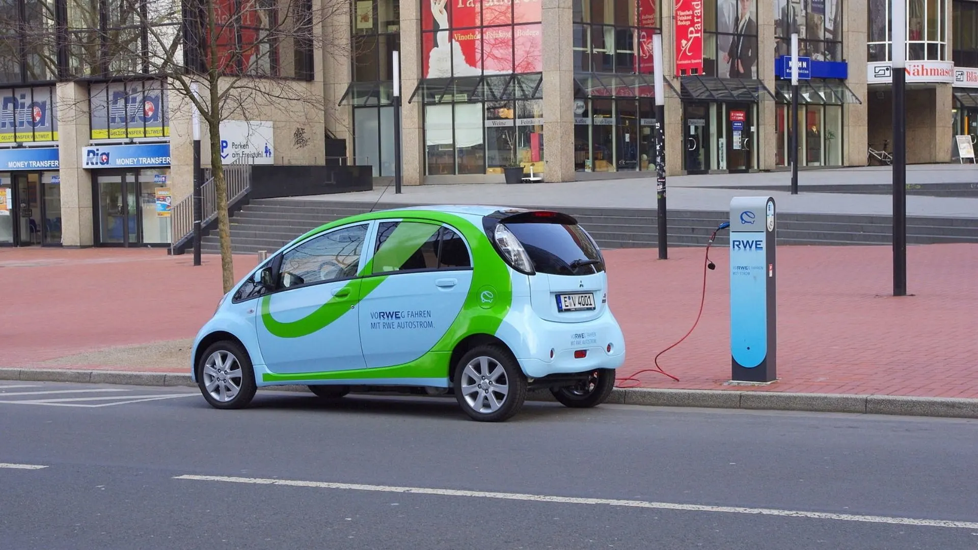 Bright, outdoor urban image featuring a streetlight and parked electric car, representing future infrastructure integration.