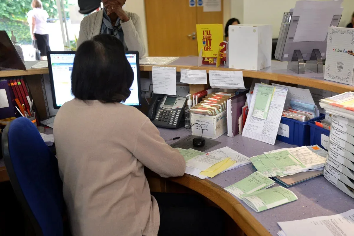 General practitioner working on a computer in a modern clinic, representing online access systems in healthcare.