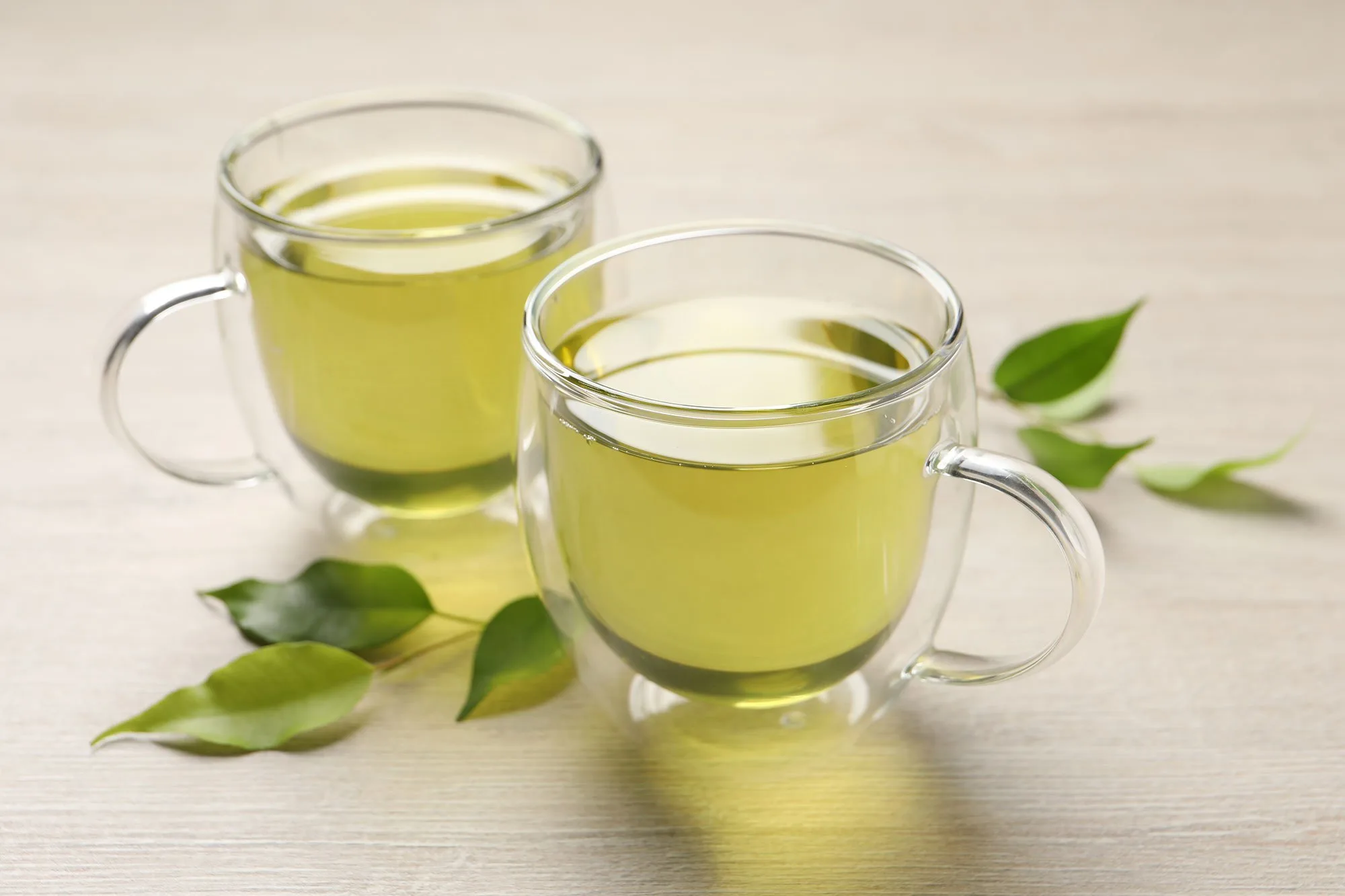 Bright and clean image showing multiple cups of green tea, effectively illustrating a variety of servings in a fresh and appealing setup.