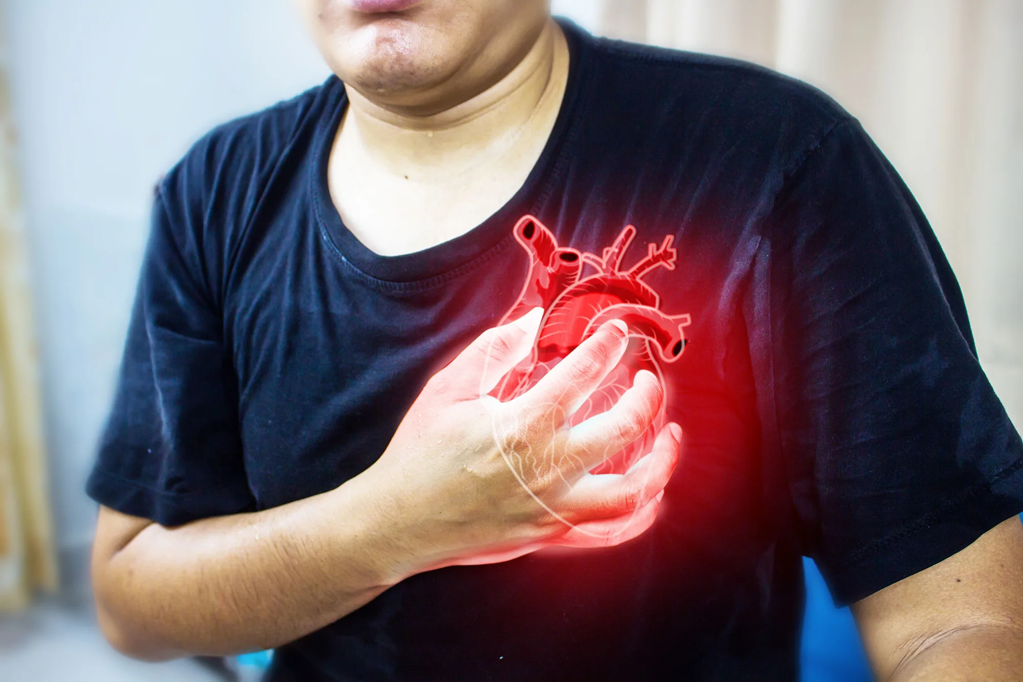 Dramatic image of a man clutching his chest, often used to depict the sudden onset of a heart attack.