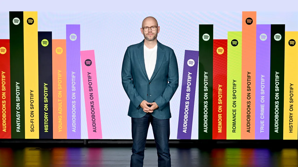 Medium-close image of Daniel Ek speaking at a Spotify event with professional background lighting, sharp and text-free.