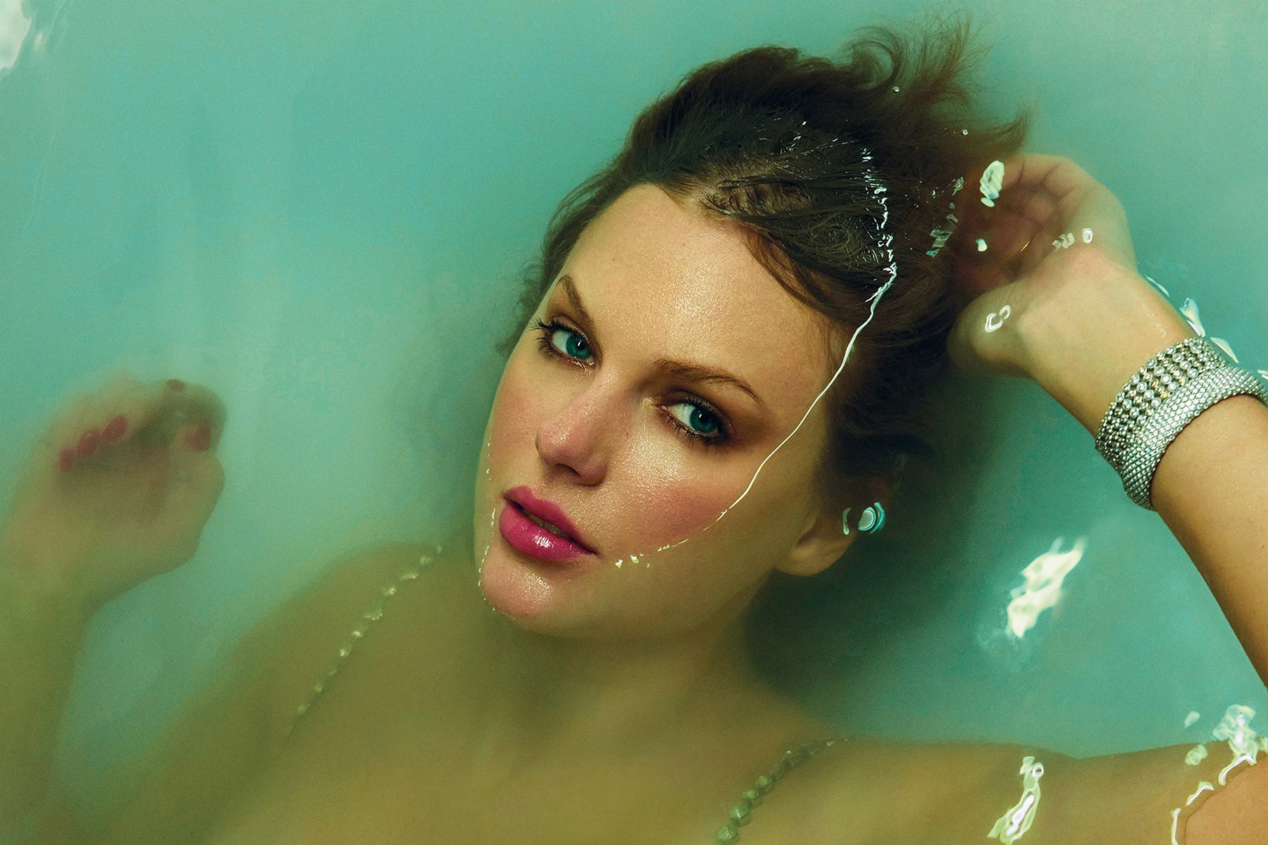 Promotional image of Taylor Swift from 'The Life of a Showgirl', showcasing her standing confidently under show lights.