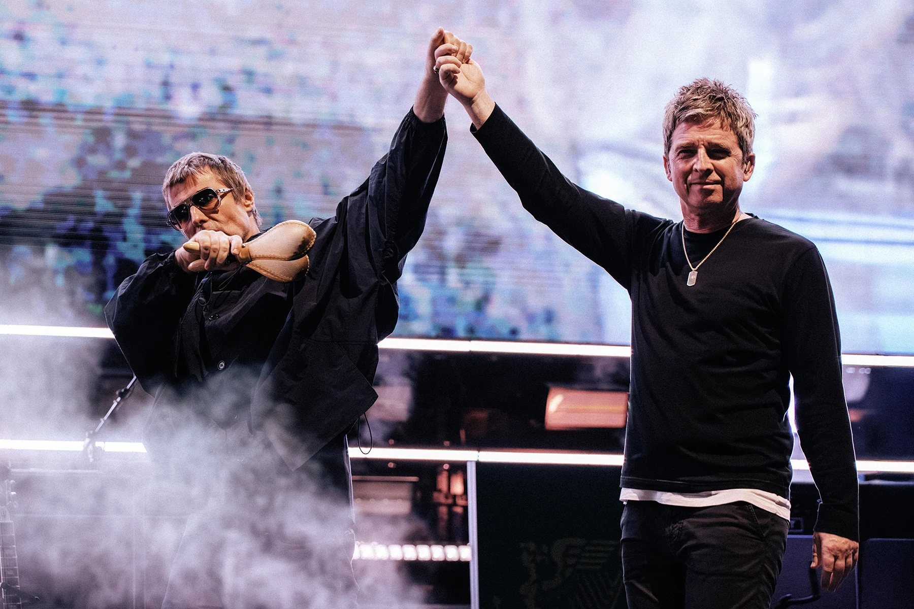 High-quality image of Liam and Noel Gallagher performing live at the Rose Bowl during the Oasis Reunion Tour 2025, capturing the energetic atmosphere.