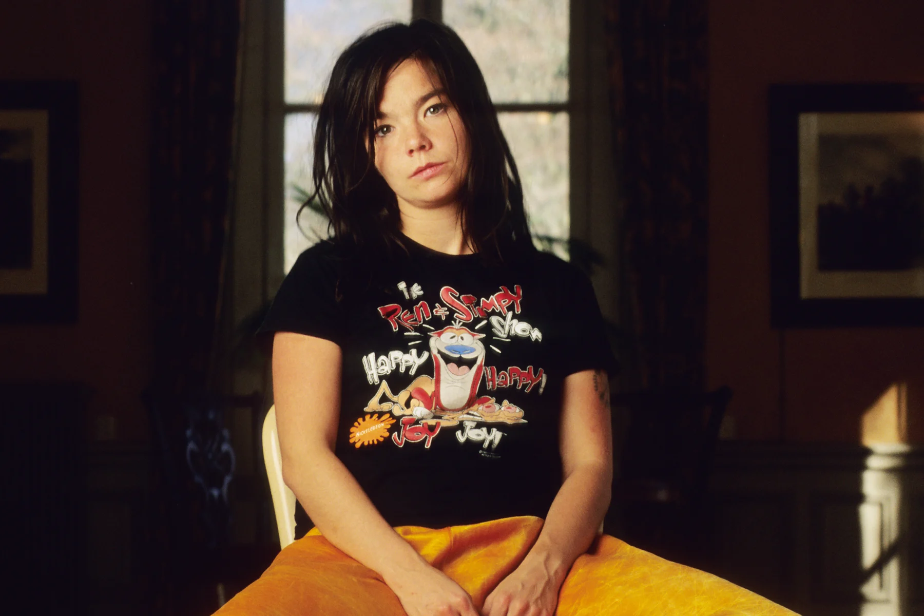 Vintage-style image of Björk with a vibrant background, reflecting her iconic 1990s look in a well-lit professional photo.