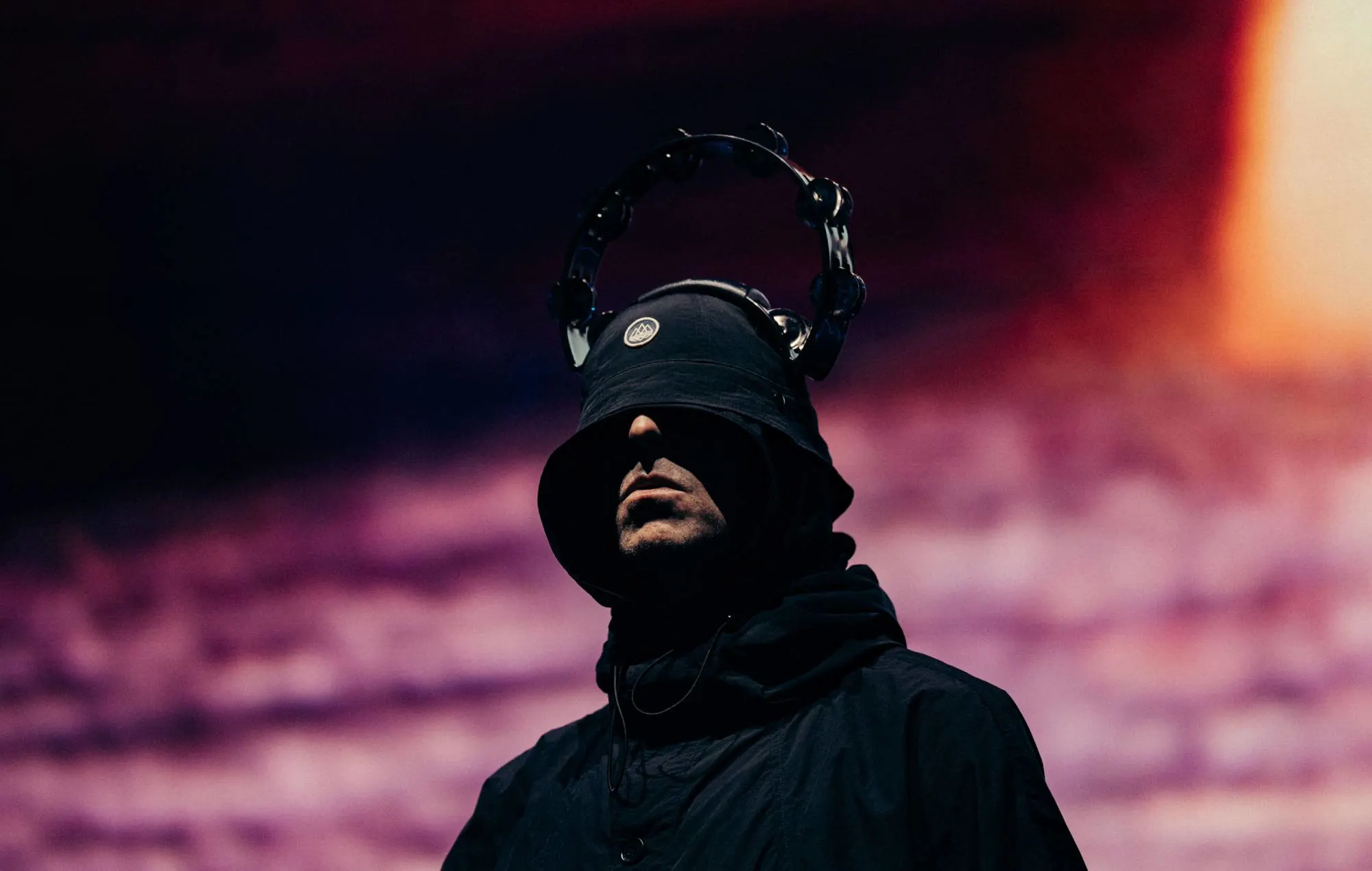 Dynamic concert shot of Oasis at Wembley, showing band members and concert lighting