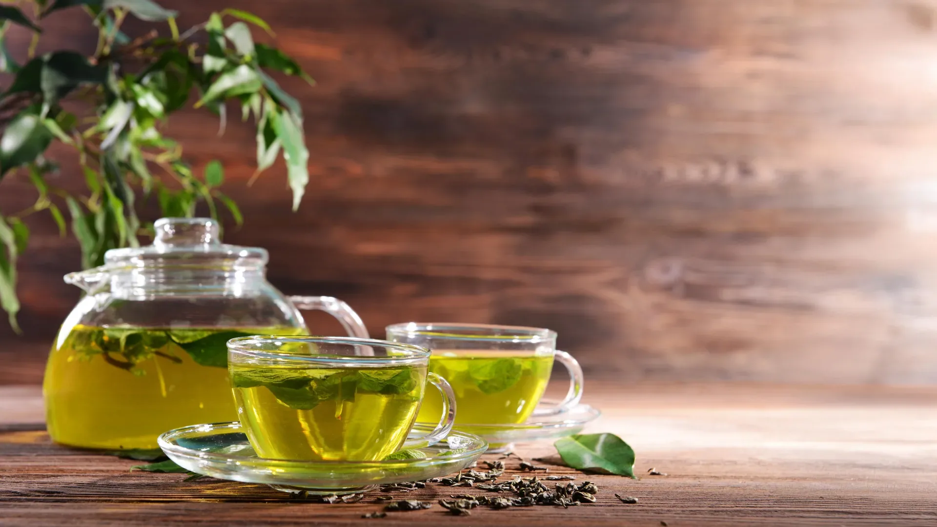 High-quality image of a cup of green tea placed on a rustic wooden table, conveying a natural and calming ambiance suitable for wellness topics.