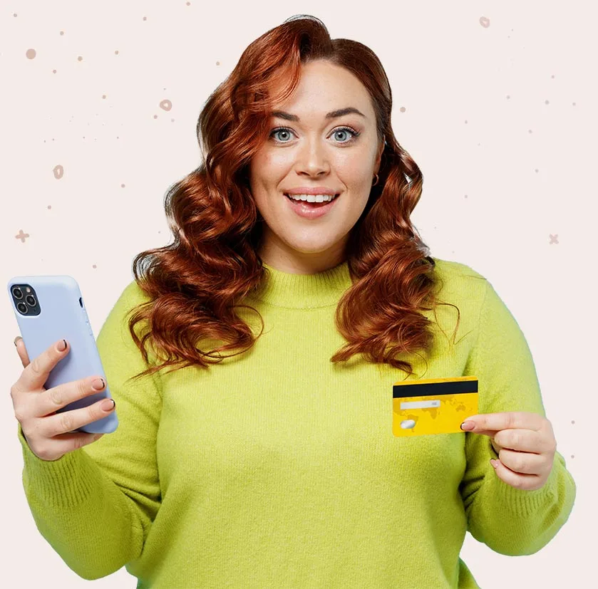 Woman smiling, holding a cellphone and a credit card.