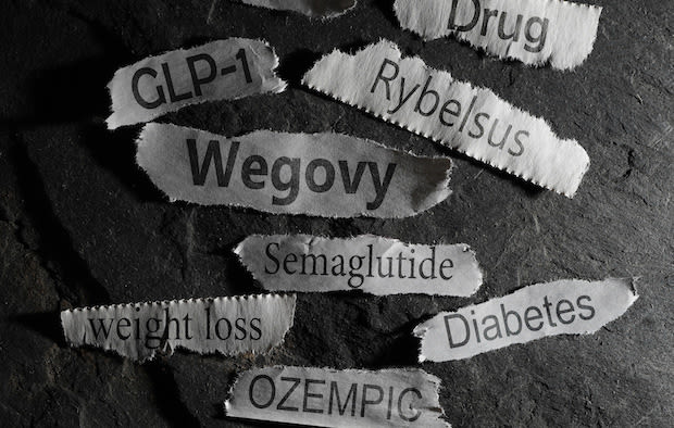 Weight loss drug words printed on ripped tabs of paper. Black and white.