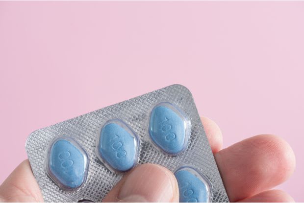 man holding Viagra tablets