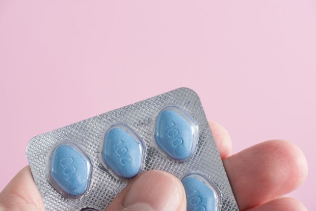 a hand holding Viagra pills