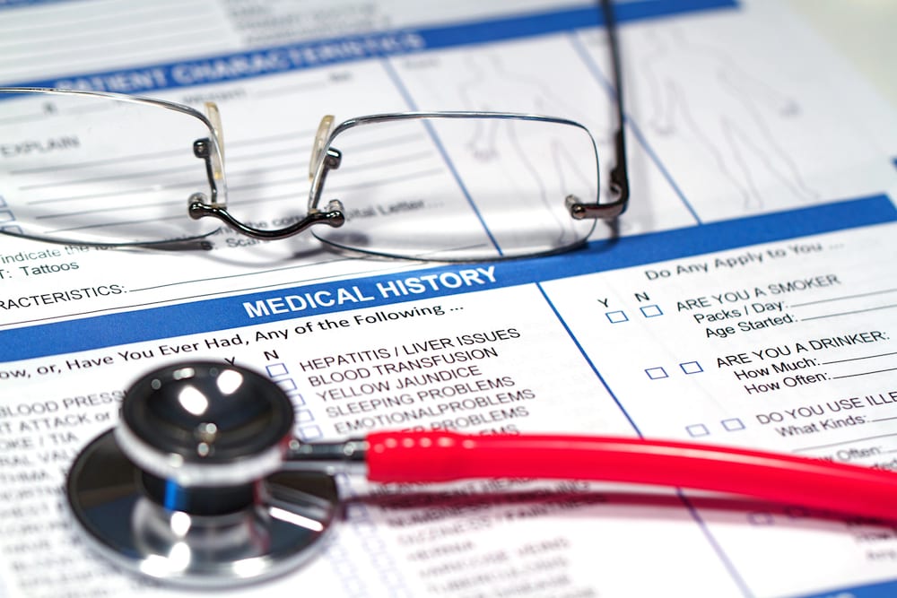 Glasses, a stethoscope, and a medical history chart
