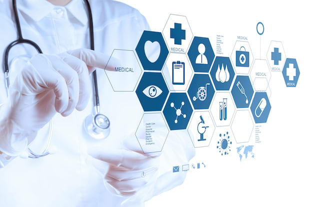 A doctor’s hands directing graphics of telehealth icons.