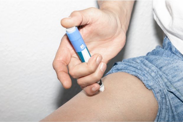 a person injecting Ozempic into their thigh