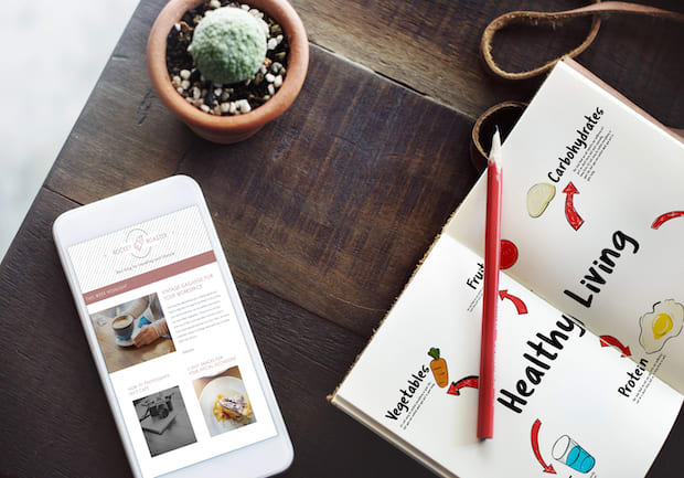 a phone, journal, and a pencil used for documenting weight loss