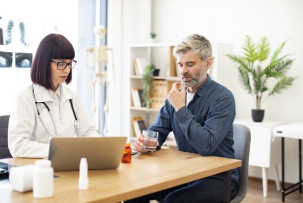 a man taking a pill at a doctor consultation