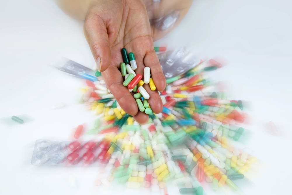 a hand holding anti-nausea pills on a blurred background