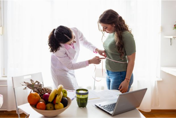 doctor measuring a patient's waist