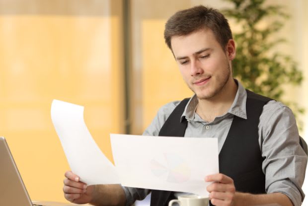 a man holding a paper in each hand