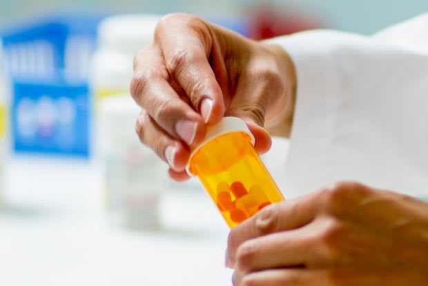 pharmacist closing a prescription bottle