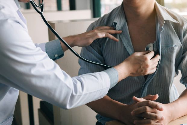 doctor listening to patient's heart with stethoscope