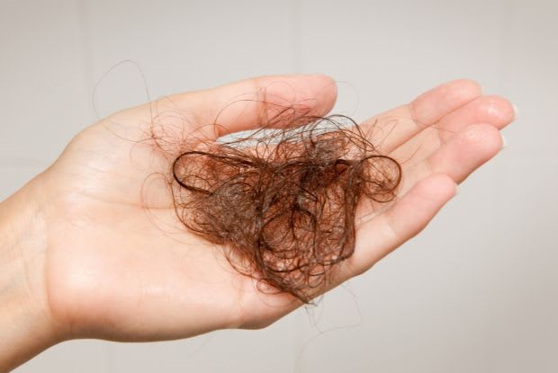 woman holding a ball of her own hair