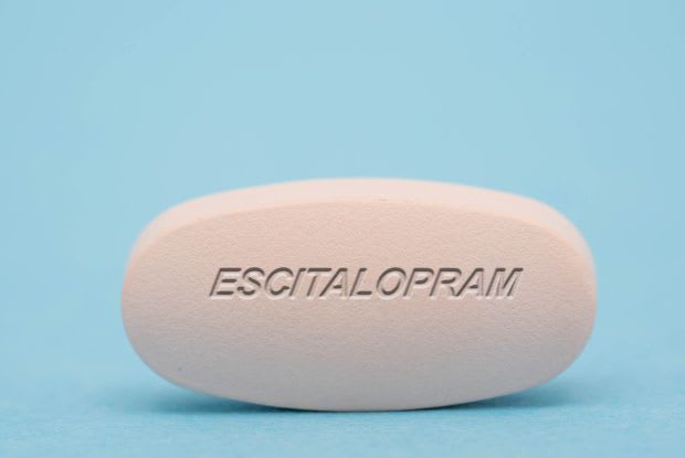 An escitalopram tablet on a blue background