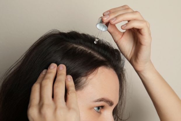 woman applying hair growth treatment