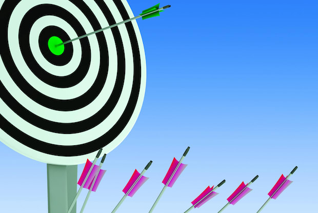 A graphic of a target on a post surrounded by arrows set against a horizon.