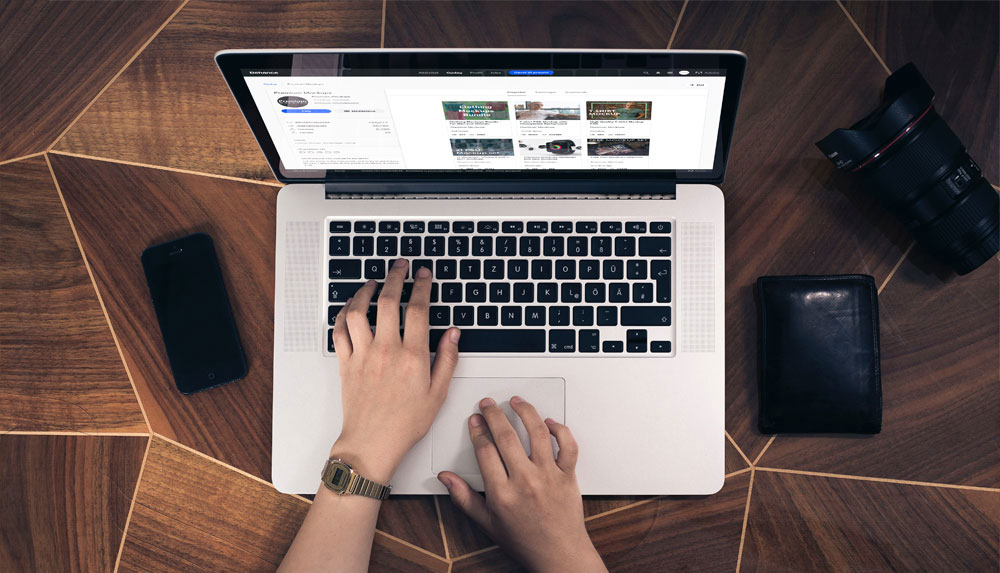 Free Woman Typing on a Macbook Pro Top View Mockup