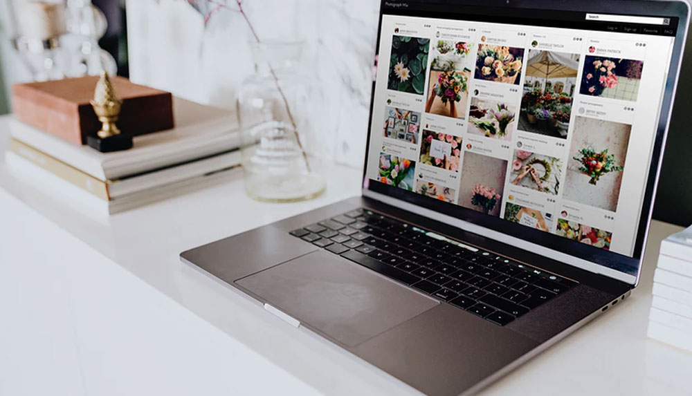 Laptop displaying Images on a Blog on a White Table