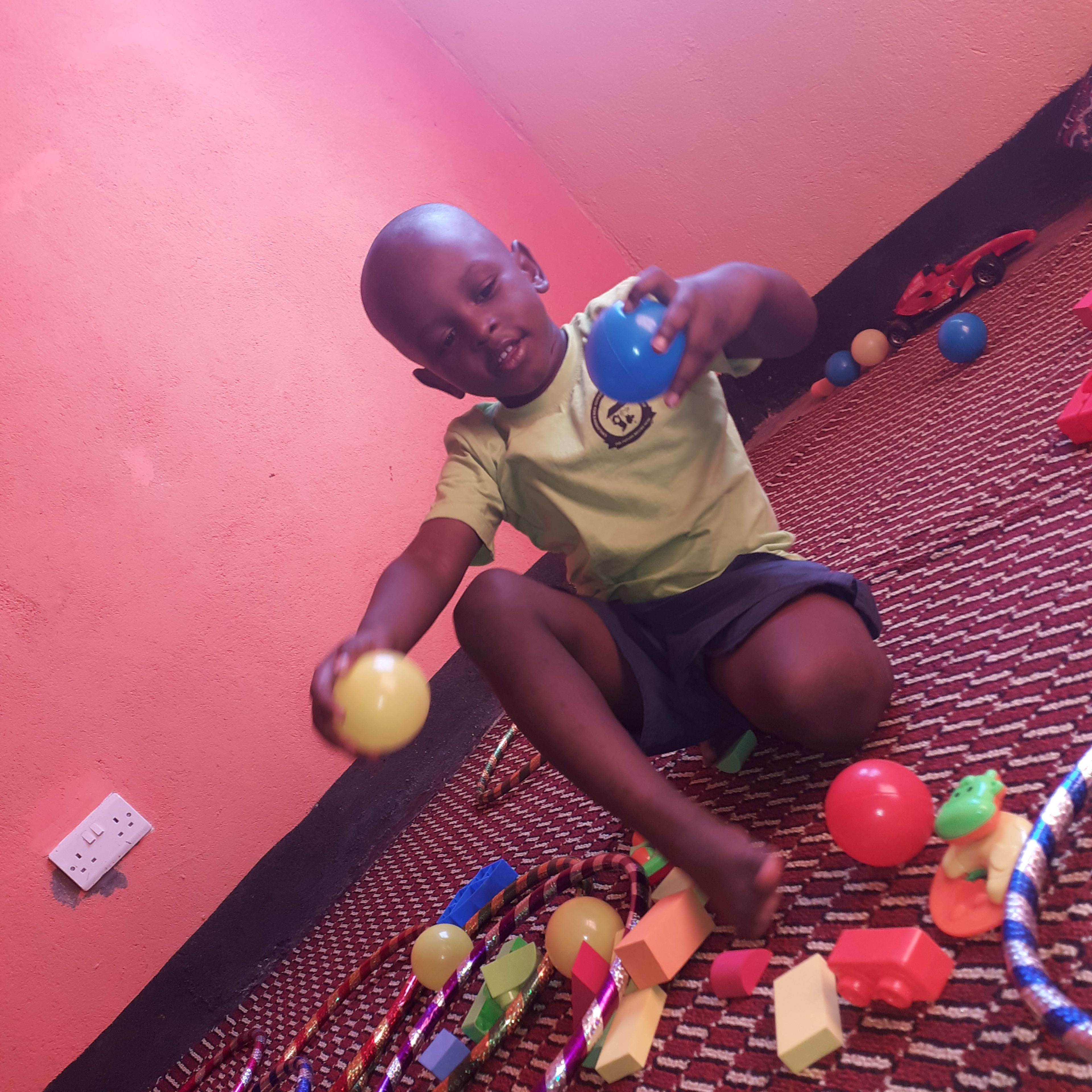 Baby Bill Edward, the school's very first learner, playing in the rest room