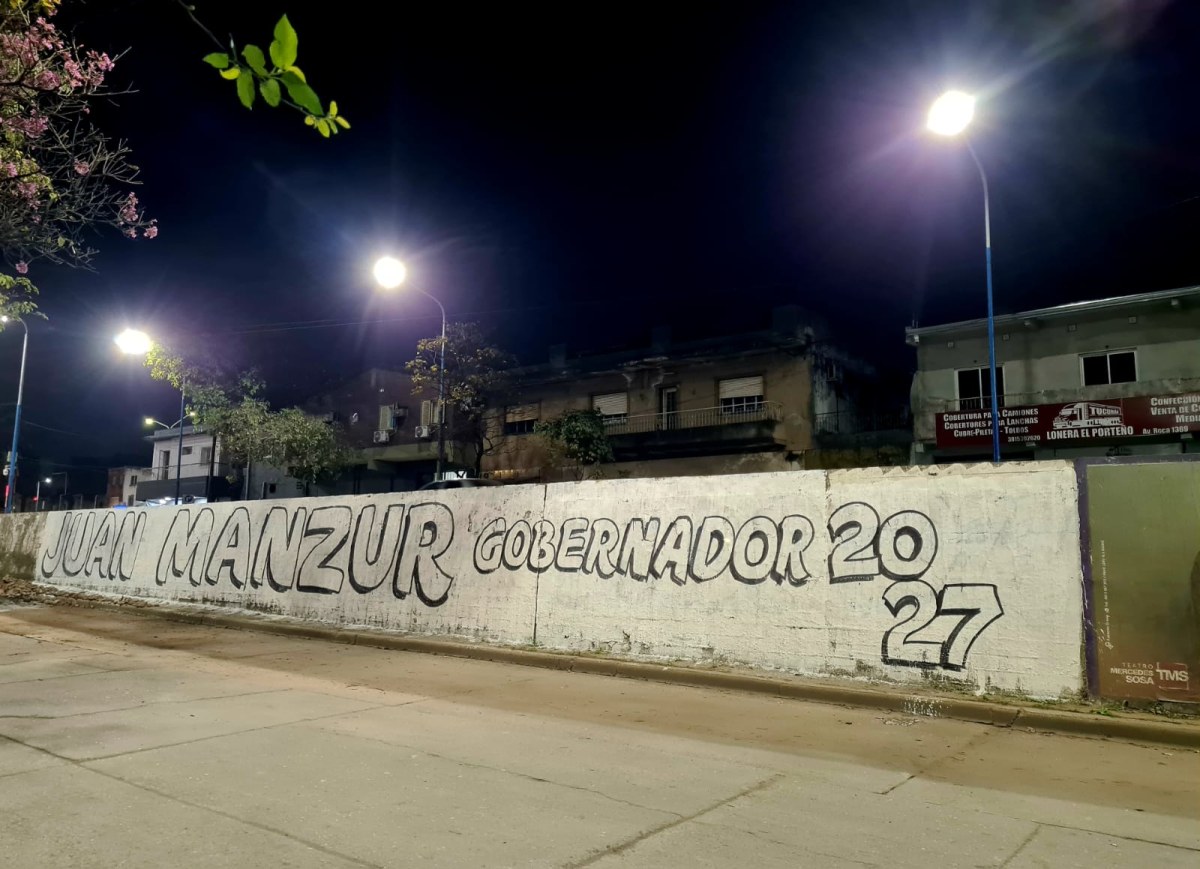 Paredón en la vía pública con la pintada en letras negras sobre fondo blanco Juan Manzur Gobernador 2027 2.jpeg