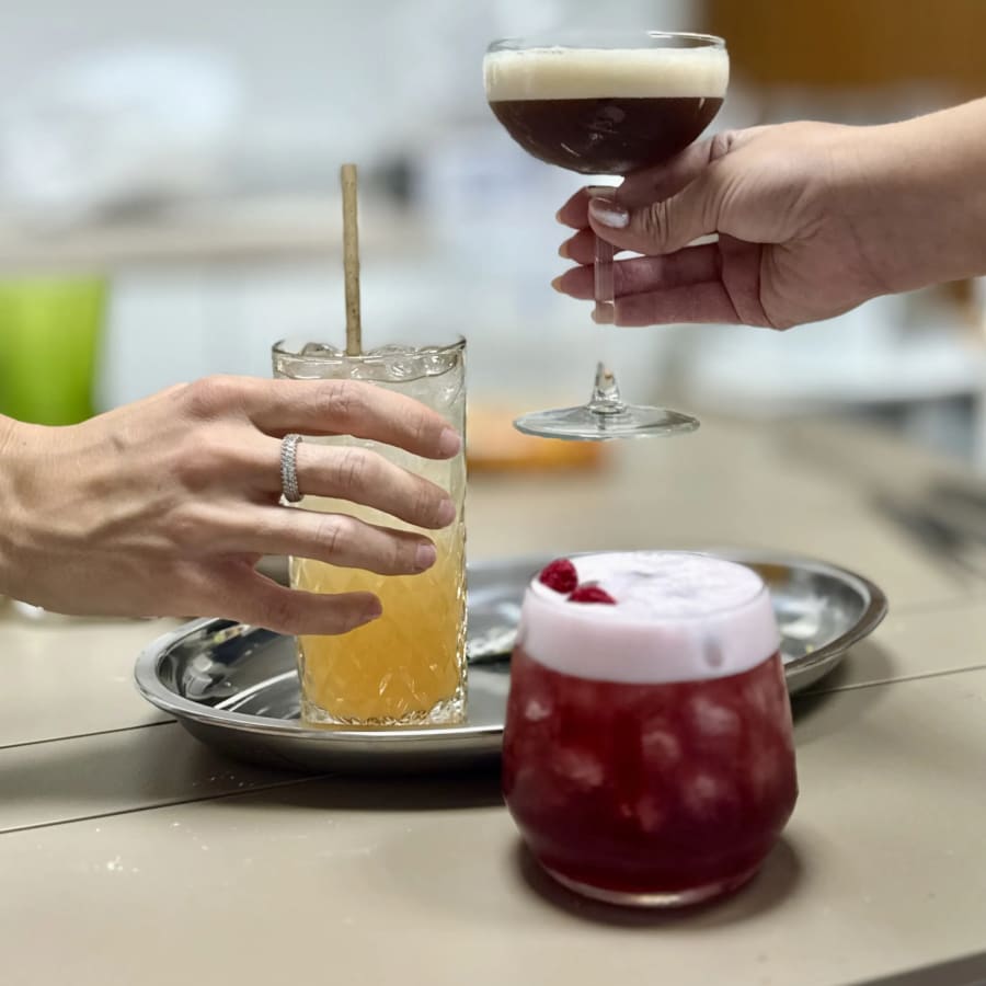Cócteles de autor servidos en la Cena Maridaje de Nomikai, en Valencia: cóctel rojo con espuma y cóctel oscuro en copa