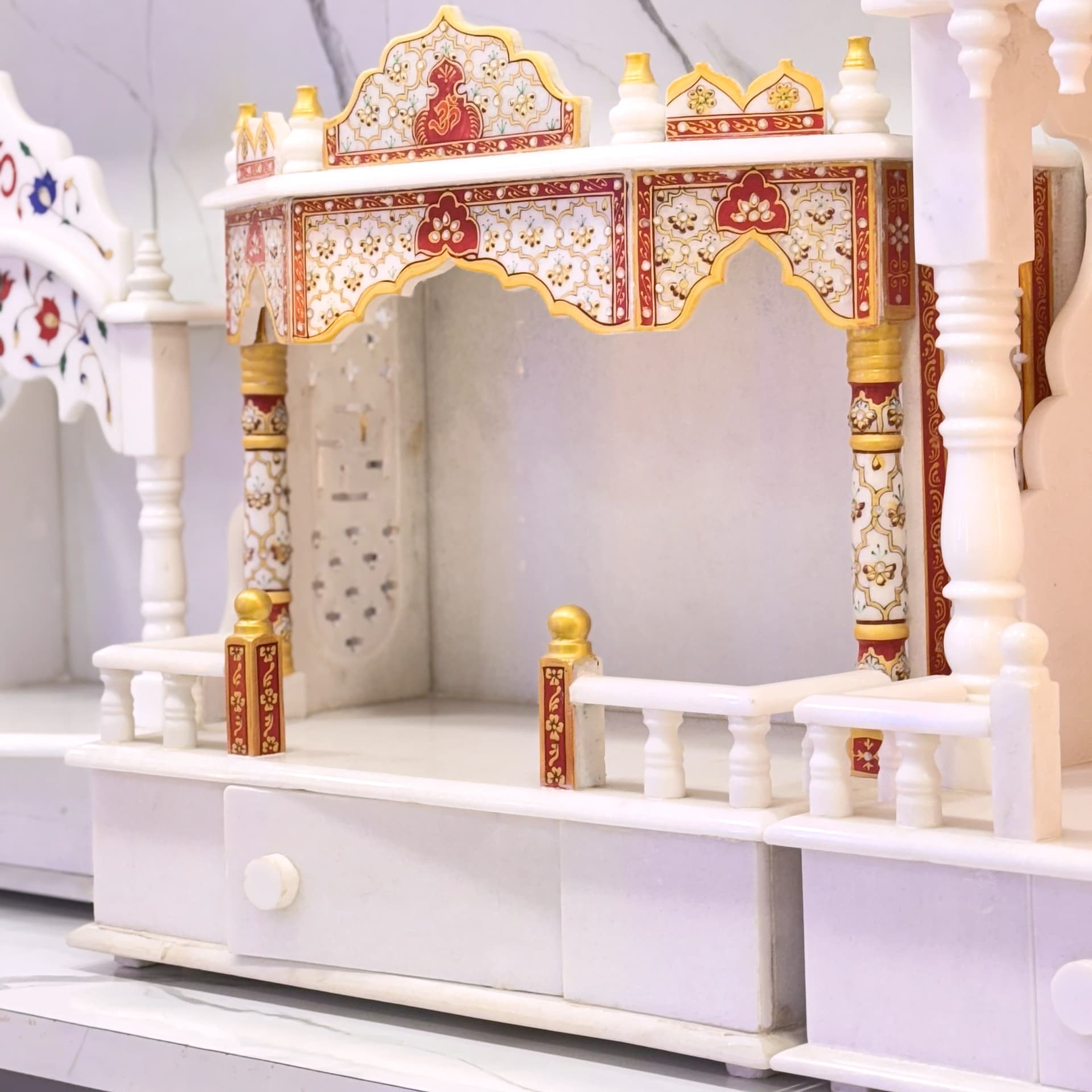 Marble temple with red and gold picked out along the carved arches and dome