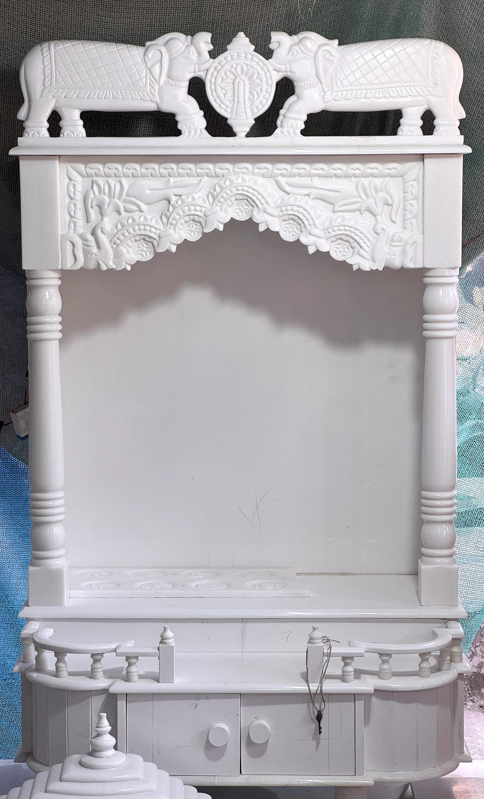 White marble mandir topped with a hathi ghumat, elephants carved at the dome