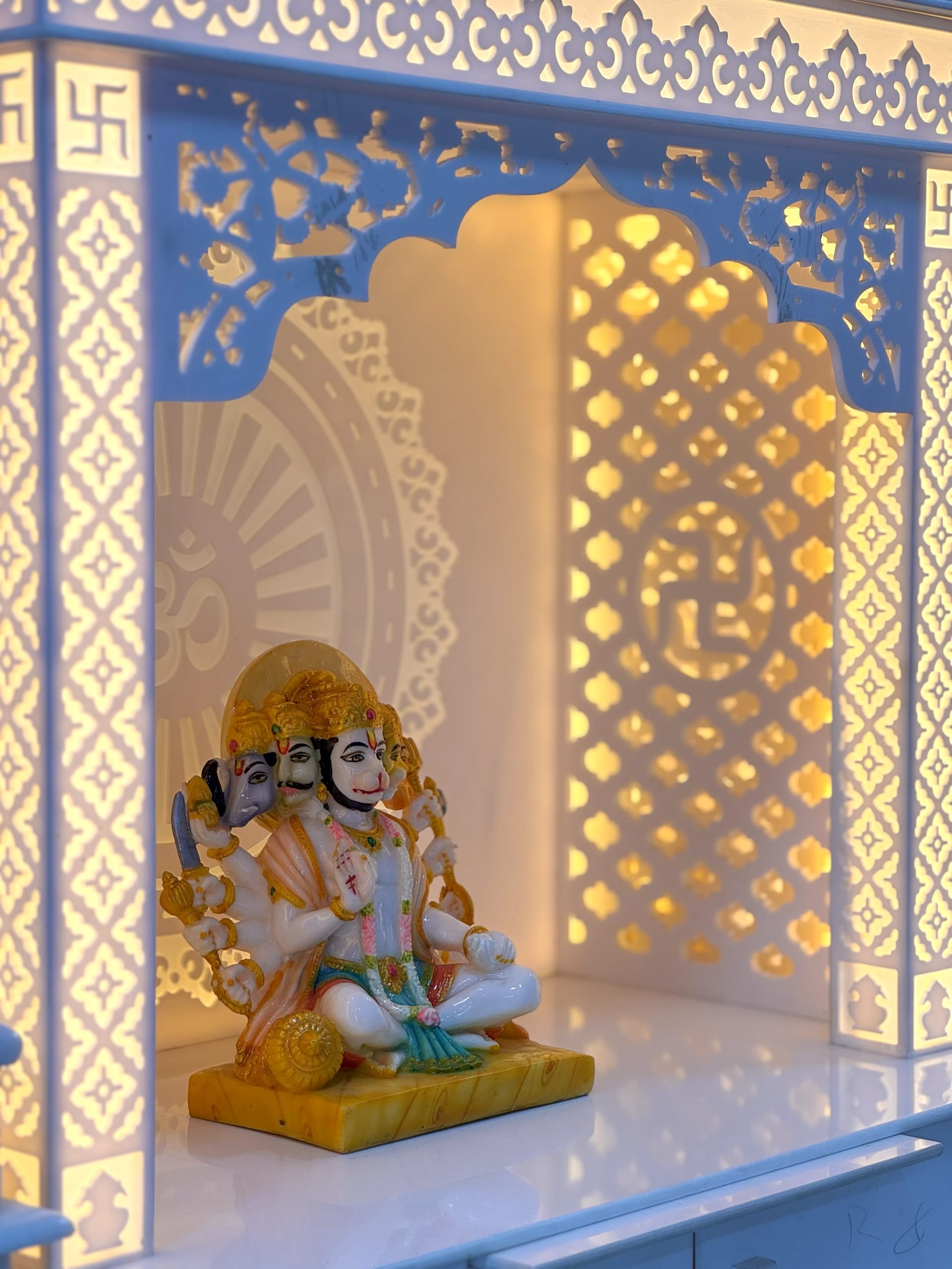 Corian mandir lit from within, the glow showing through the back panel