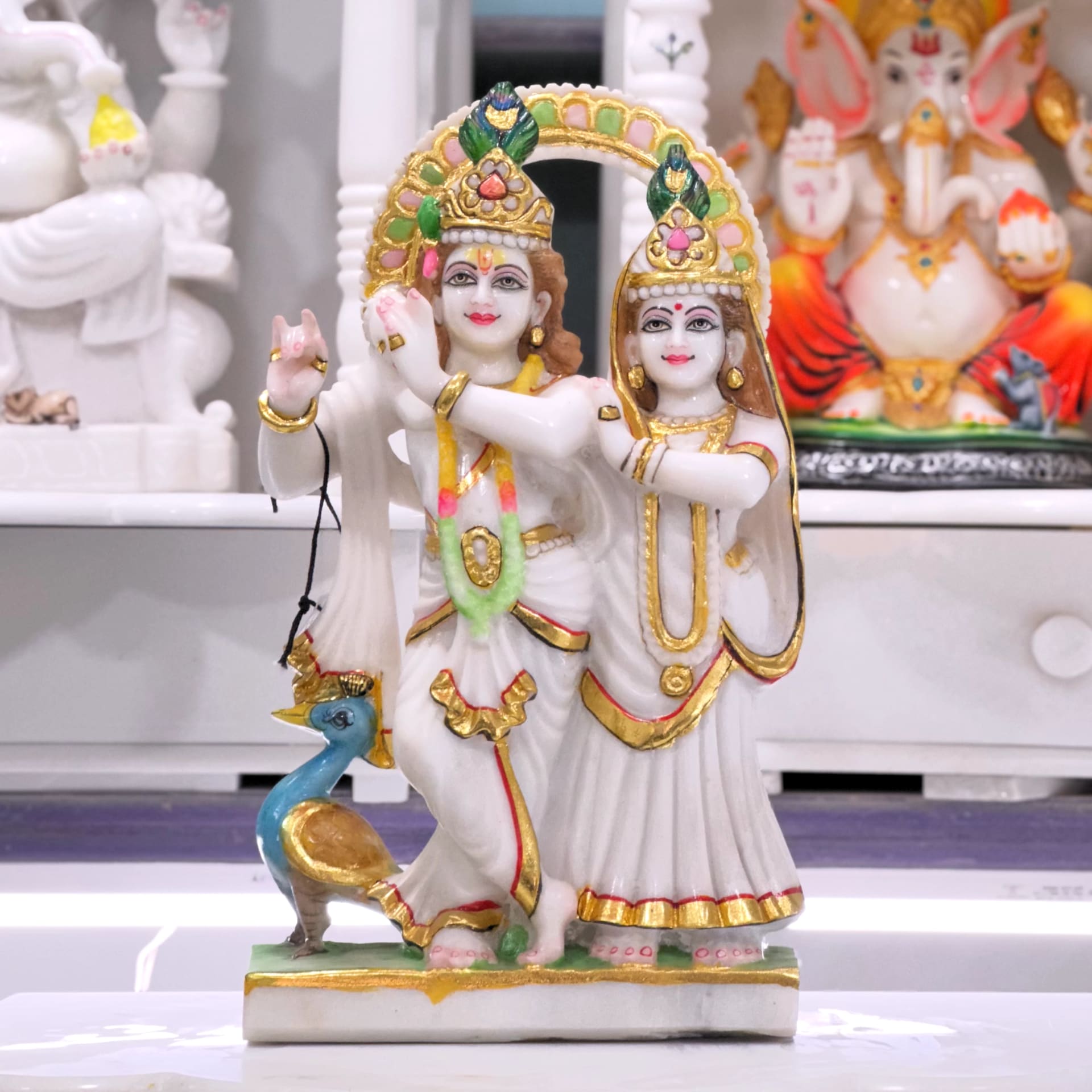 Radha and Krishna standing together, carved from a single block of pale marble