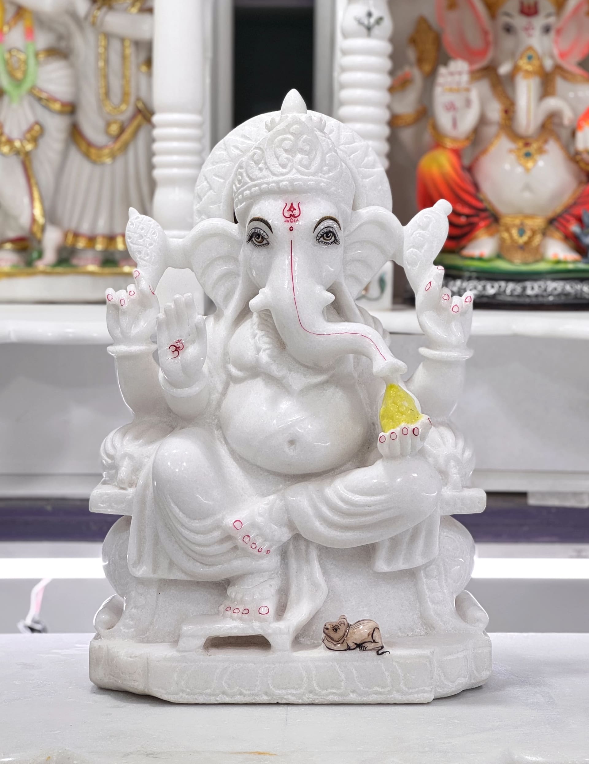 Ganesha murti in white Italian marble, seated with one hand raised in blessing