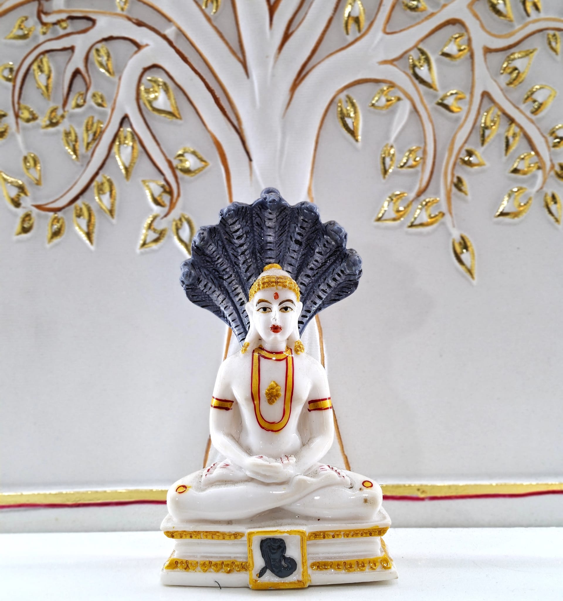 Seated Jain Tirthankar murti in white marble, hands resting in the lap