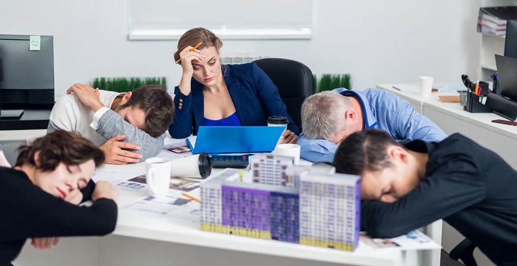 Group of corporate staff napping together on a desk.