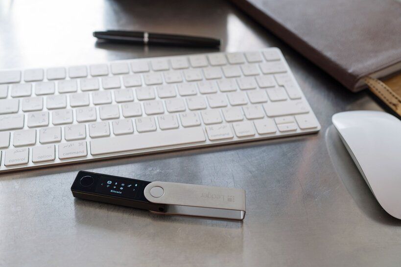 A hardware wallet next to a computer keyboard to depict crypto wallet security discussion