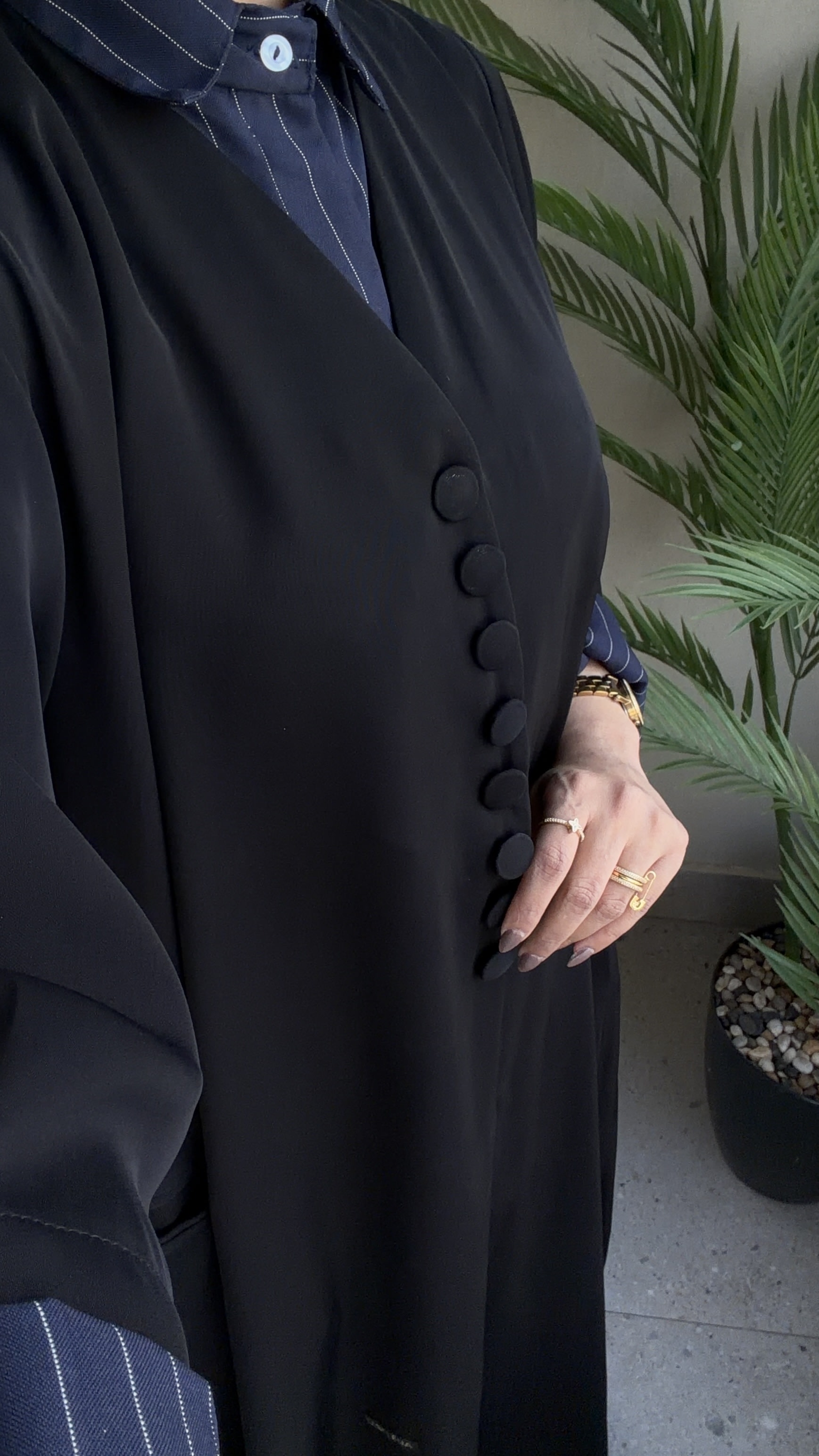 عباية قميص سوداء بياقة مخطّطة وأزرار