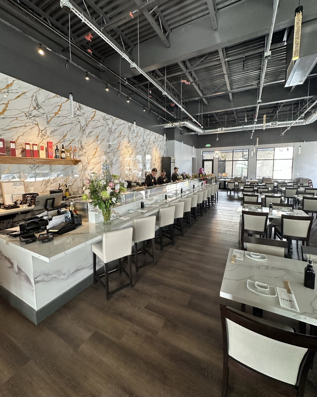 Izumi Sushi dining room with marble waterfall counter and floral arrangement