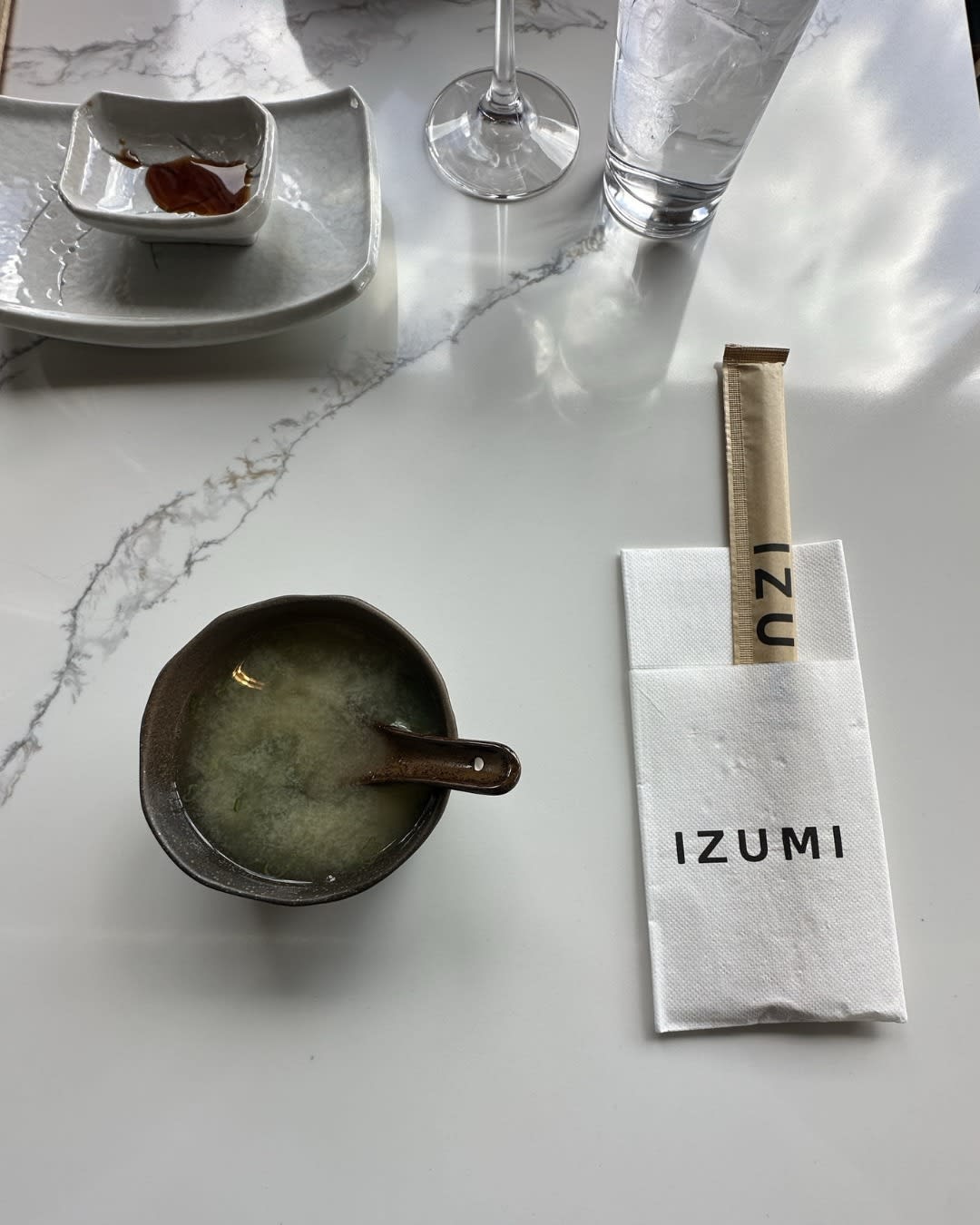 Izumi Sushi miso soup in branded ceramic with chopsticks and napkin