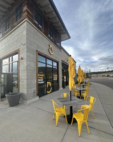 Starbird Chicken patio seating with yellow umbrellas