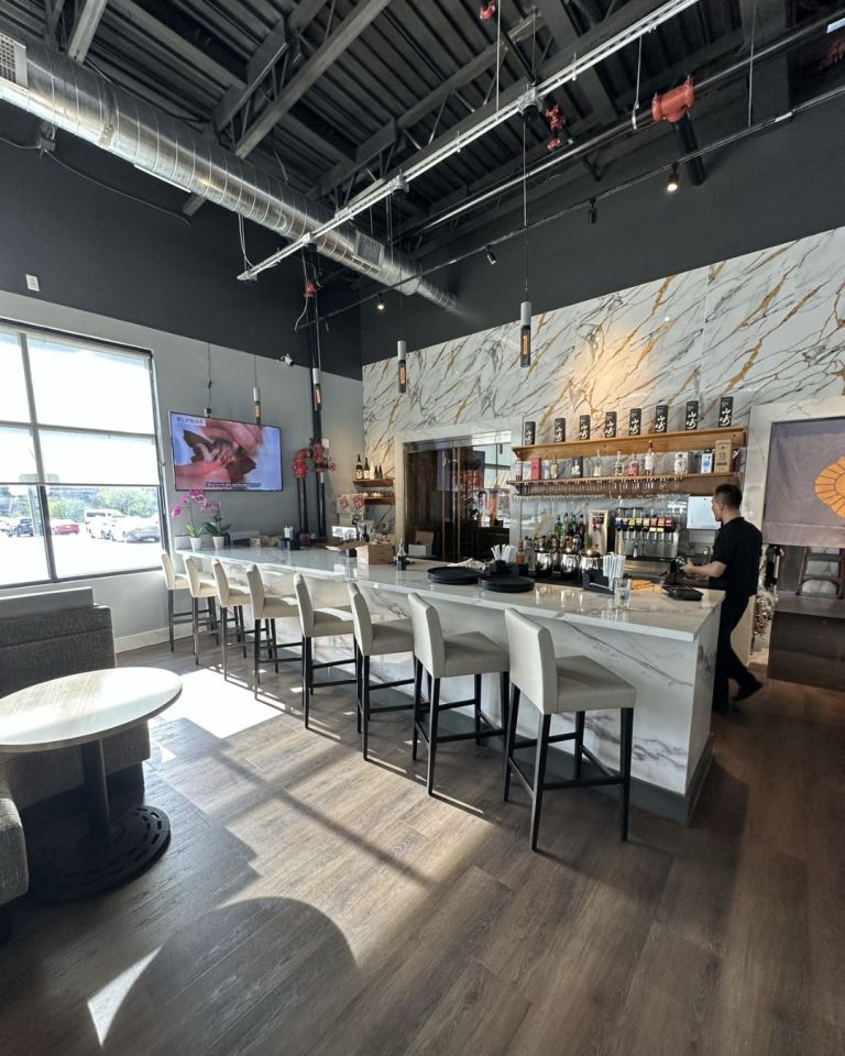 Izumi Sushi sushi bar with chef and bottle wall