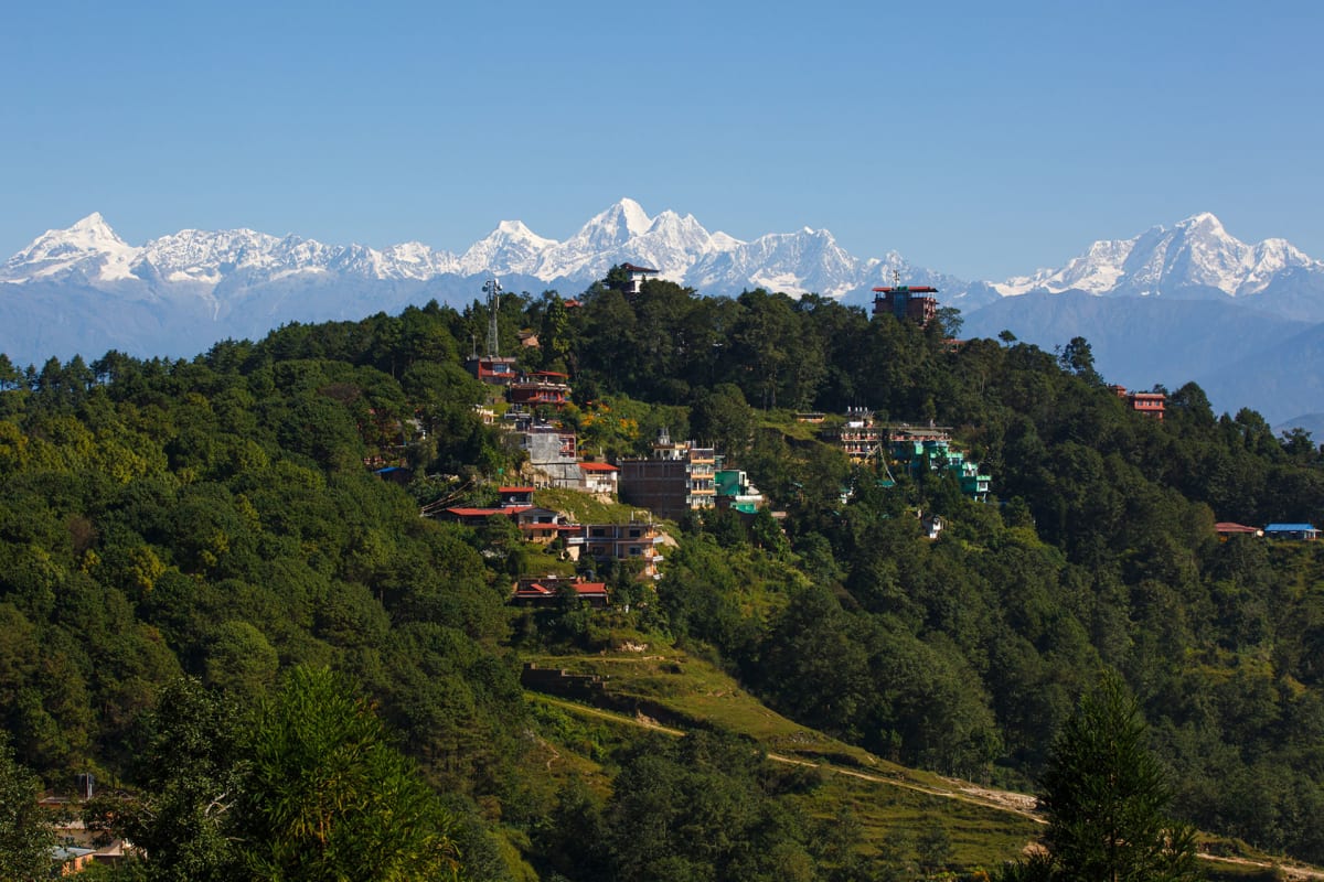 Forested hills of Nagarkot on the Kathmandu valley rim with a line of snow peaks on the horizon