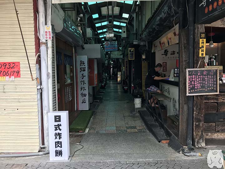看板の下の通路を通る