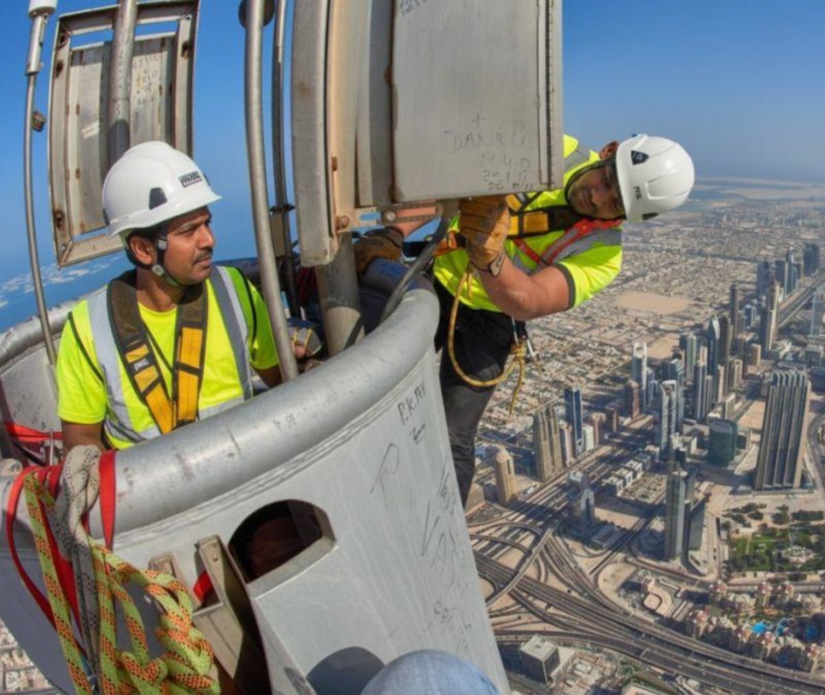 Workers installing glass panels on Burj Khalifa during construction