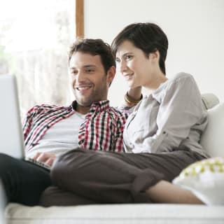 2016 Centex Stock Image, 1240 x 1240 Square Crop, Mycentexbenefits_702_couplesearchgforhomeonline_1240x1240.jpg; Couple relaxing together on sofa with laptop computer